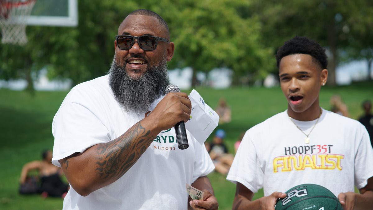 Everyday Mentors founder Lee Lewis speaks into the mic during a community event at Liberty Park.  (BrewCity Flash Photography)