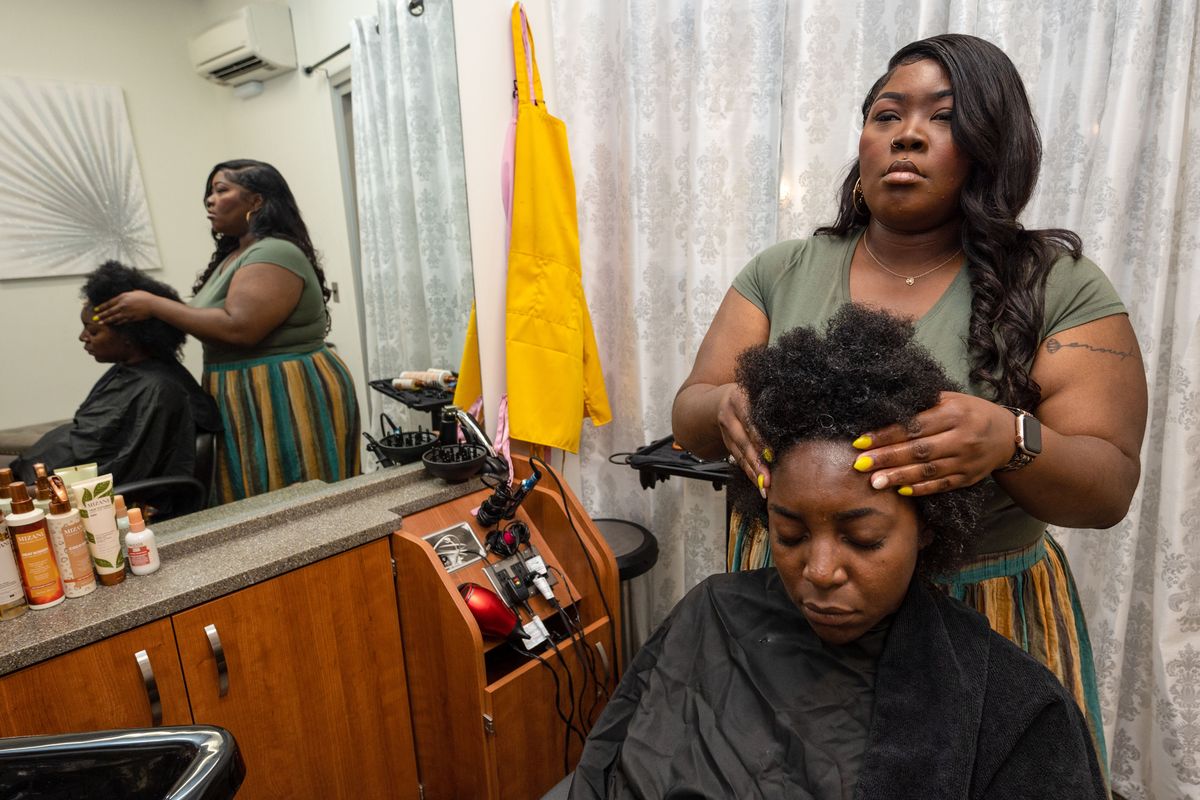 After using leave-in conditioner, hairstylist Kameishi Williams messages scalp conditioner into client Chelsea Messan’s hair. Williams is one of the only Black hairdressers in Spokane. Williams is also a state spokesperson for the Crown Act. (COLIN MULVANY/THE SPOKESMAN-REVIEW)