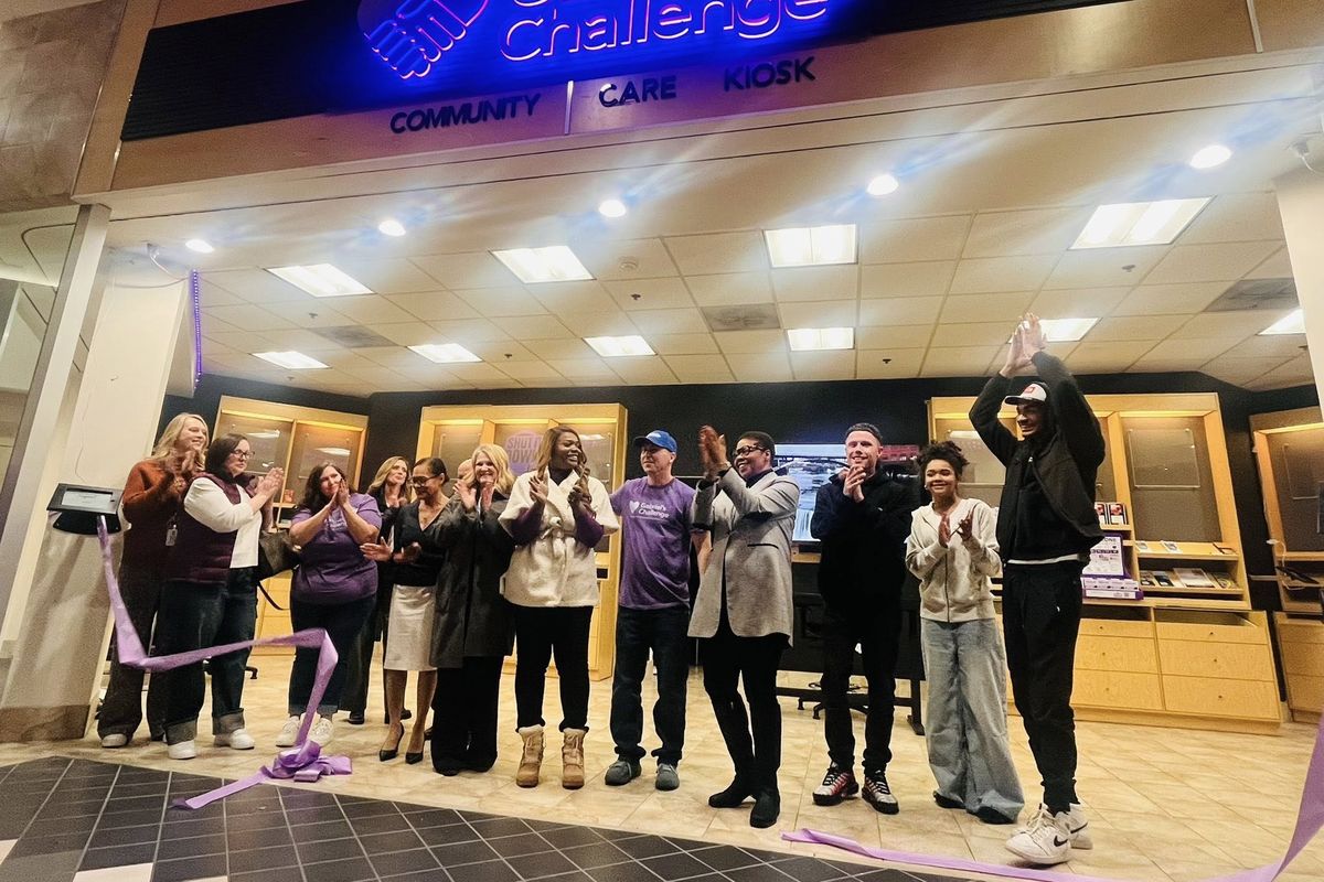Kitara Johnson-Jones, center in white coat, claps after community members cut the ribbon on the opening of Gabriel’s Challenge in NorthTown Mall. (Courtesy)