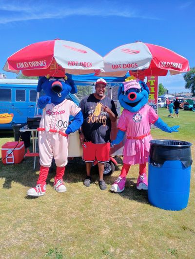 Cedric “Ced” Dickerson servers hot dogs along with Spokane Indians mascots Otto and Doris.  (Courtesy)