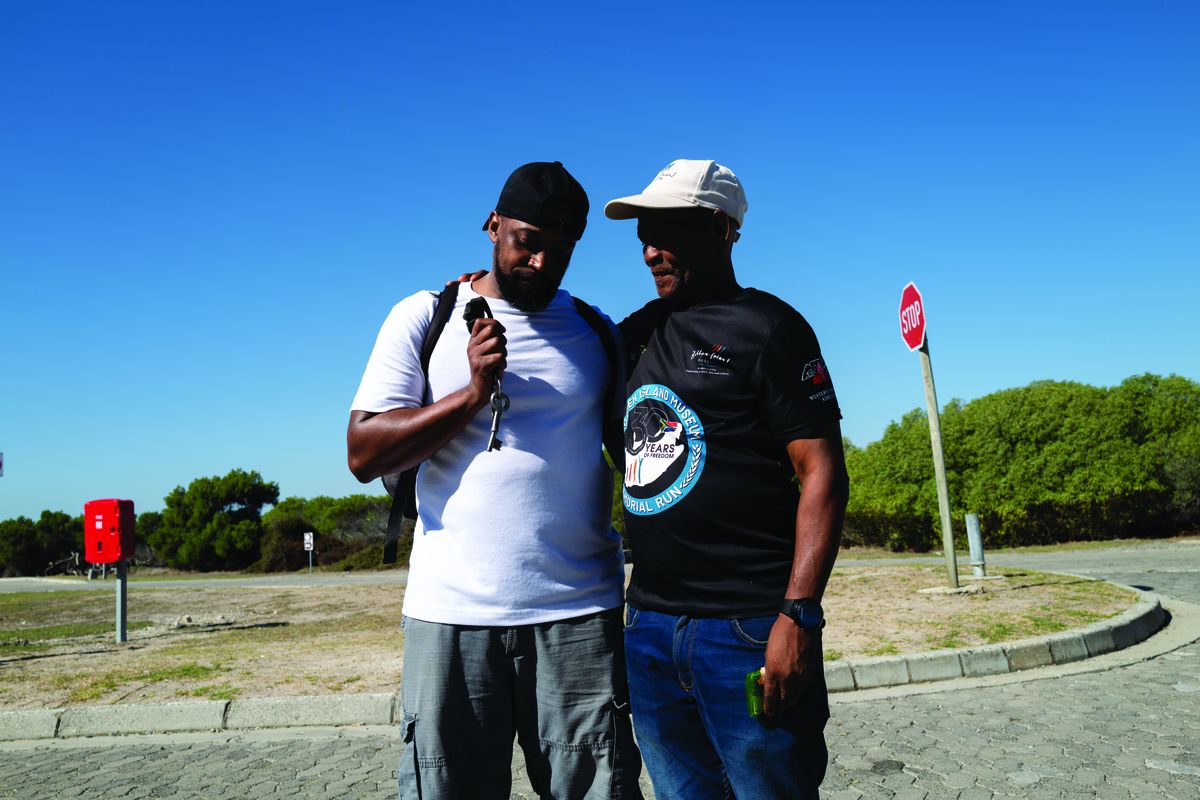 A former political prisoner at Robben Island holds the original key used to lock cells during apartheid, offering firsthand testimony during a guided tour.  (Michael Bethely)