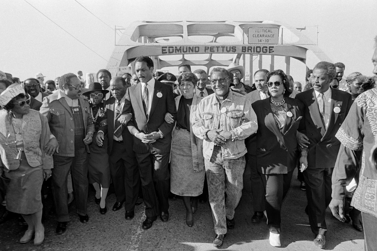 The Rev. Jesse Jackson, center left, and civil rights figures lead a march across the Edmund Pettus Bridge in Selma, Ala., on the 25th anniversary of “Bloody Sunday,” on March 6, 1990. Jackson, whose impassioned oratory and populist vision of a “rainbow coalition” of the poor and forgotten made him the nation’s most influential Black figure in the years between the crusades of the Rev. Dr. Martin Luther King Jr. and the election of Barack Obama, died on Feb. 17. (Michelle V. Agins/The New York Times)
